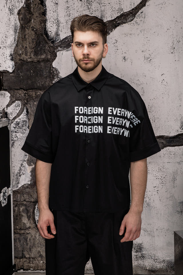 Wicked33 Foreign oversized shirt in deep black, large white “FOREIGN EVERYWHERE” text print on chest and sleeve